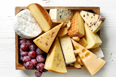 Different kinds of cheese inside a wooden box.